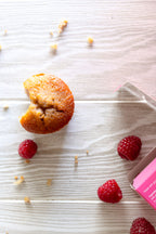Muffin with raspberries on a textured surface